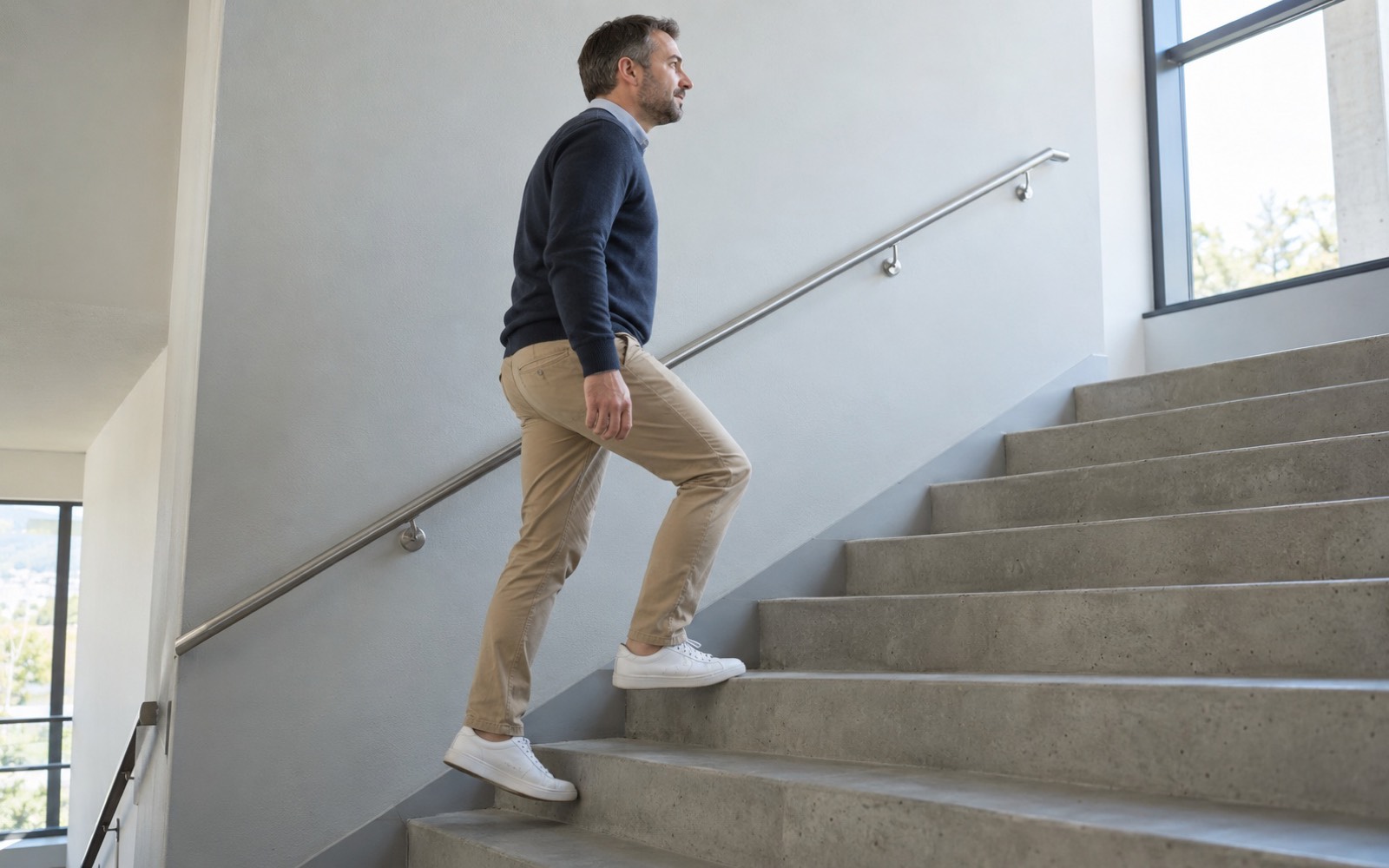 Man walking up the stairs instead of taking the elevator