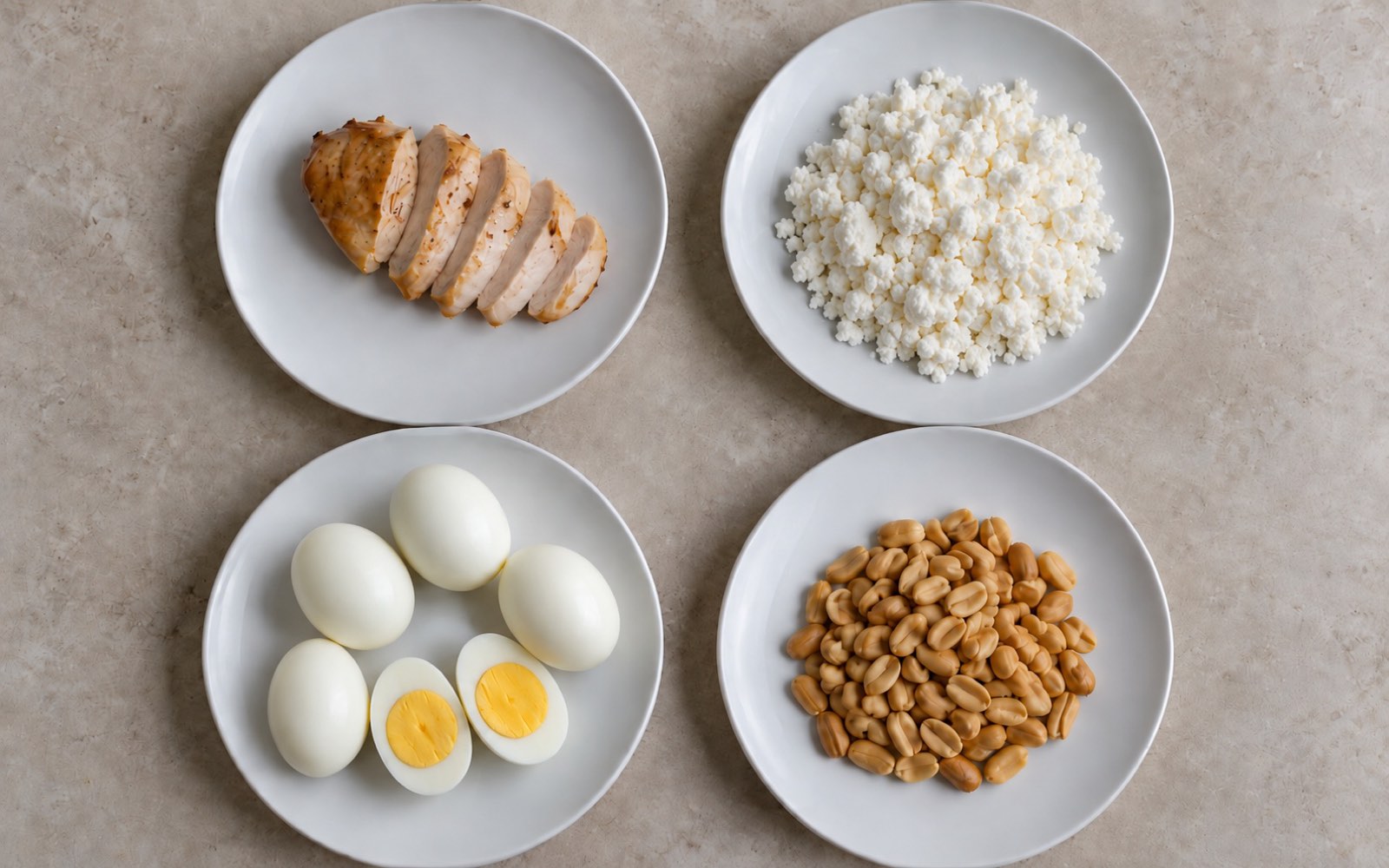 Four identical plates from above: sliced roasted chicken breast, a mound of farmer's cheese, five peeled hard-boiled eggs and a heap of roasted peanuts